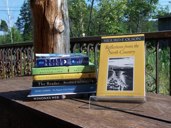 Books in a pile on porch bench.